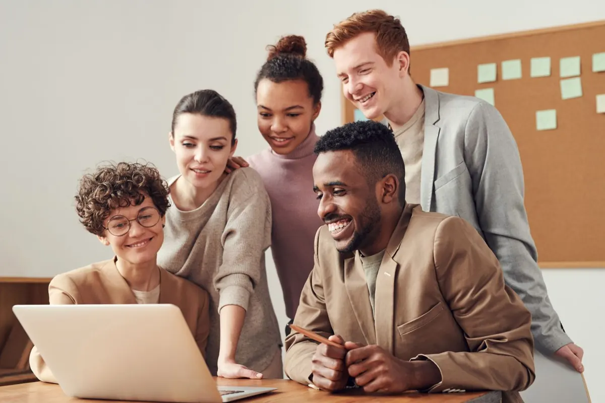 Small team reviewing social media work together on a laptop