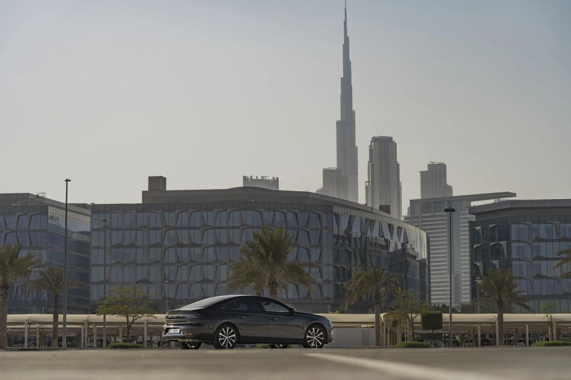 Sedan parked on a Dubai road with the skyline behind